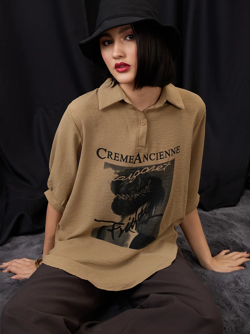 جلو باص بلوزة نسائية واسعة بياقة وأكمام قصيرة وطبعة رسومية وحافة غير متساوية